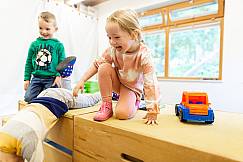 Kinder klettern über Holzkisten